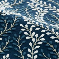 a blue and white fabric with small leaves on the top, as if it were embroidered