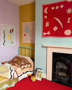 a bed room with a neatly made bed next to a fire place and paintings on the wall