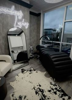 a black and white living room with a large mirror on the wall next to a couch