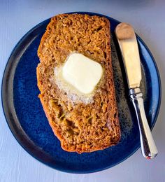 a piece of bread on a blue plate with butter