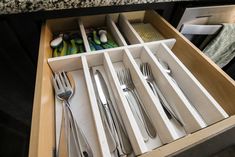 an open drawer with utensils in it