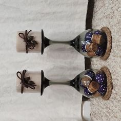 three wine glasses with decorations on them sitting on the floor next to each other and tied in twine