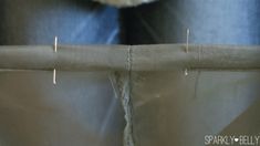 the back end of a pair of jeans with needles sticking out of them