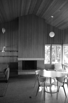 a black and white photo of a living room with wood paneling on the walls