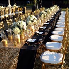 a long table is set with gold chairs and white flowers