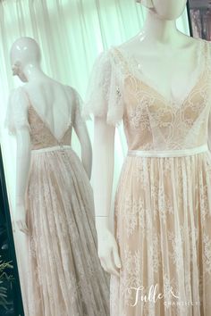 two mannequins dressed in wedding gowns and dresses with lace on them