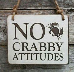 a sign that says no crabby attitudes hanging on a wooden wall