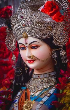 a close up of a statue of a woman with jewelry on her face and headdress