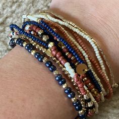 a close up of a person's arm wearing bracelets with beads and charms