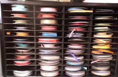 a cabinet filled with lots of different colored spools