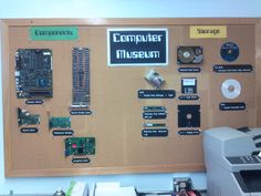 a cork board with various electronic components attached to it and a printer on the side