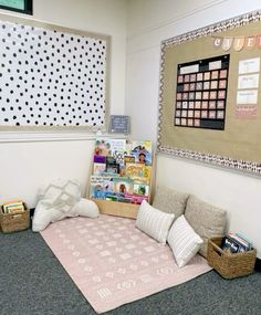 an office cubicle with books and magazines on the floor next to a pink rug