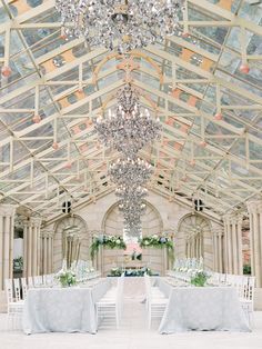 an indoor wedding venue with chandeliers and tables