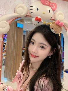 a woman with long hair wearing hello kitty headbands in front of a mirror