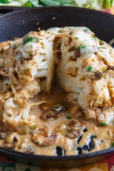 cauliflower covered in gravy sitting in a skillet on a table