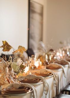 the table is set with plates and place settings