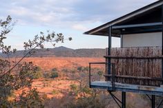 a view from the top of a tree house with mountains in the distance behind it