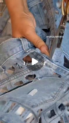 someone using scissors to cut the holes in their jeans