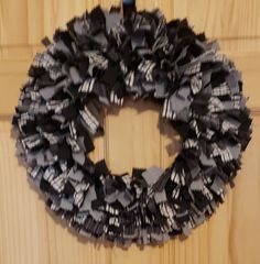 a close up of a wreath on a door with black and white ribbons hanging from it