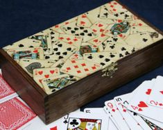 a wooden box filled with playing cards on top of a table