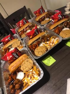 several trays filled with different types of food on top of a wooden table next to each other