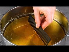 a person using a brush to clean a pot