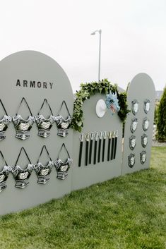 a large sign that is on the side of a grass field with flowers growing out of it