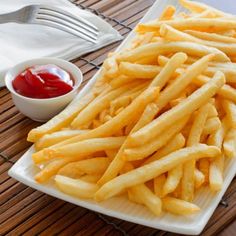 french fries on a plate with ketchup and sauces next to it,