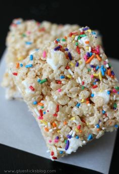 rice krispy treats with sprinkles are on top of a piece of paper