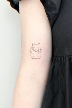 a small cat tattoo on the left arm