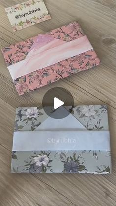 three different boxes sitting on top of a wooden table next to an envelope and card holder