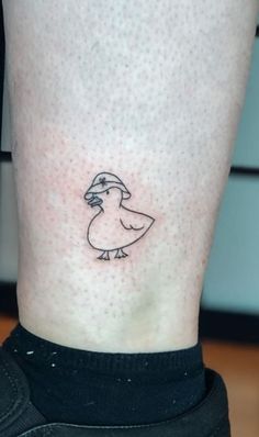 a small bird tattoo on the right side of the leg, it is black and white