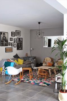 a living room filled with furniture and pictures on the wall