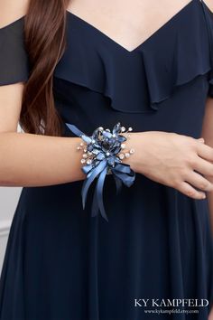 a close up of a person wearing a blue dress with a flower on it's wrist