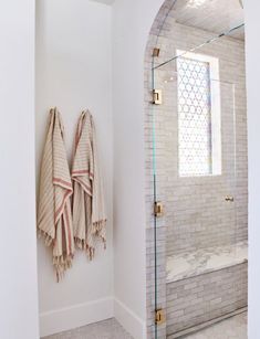 two towels hanging on the wall next to a shower