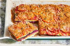 a pan filled with sliced up pizza on top of a white plate next to a fork