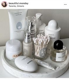 a white tray topped with lots of different types of skin care products and cosmetics on top of a table