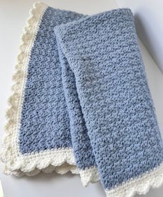 two blue and white crocheted dishcloths sitting on top of a counter