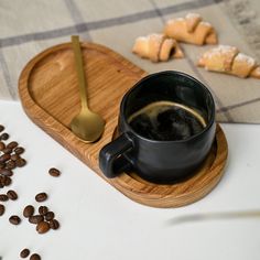 a cup of coffee sitting on top of a wooden tray