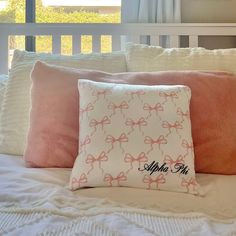 a bed with pink and white pillows on top of it