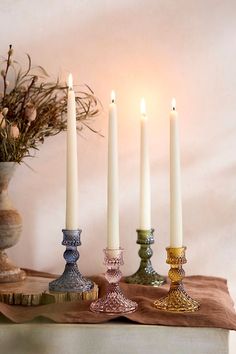 four candles are lined up on a table