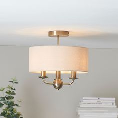 a chandelier hanging from a ceiling in a room with books on the table