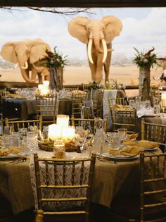 the tables are set with place settings for two people to sit at, and an elephant statue is in the background