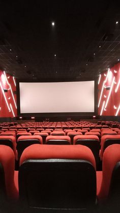 an empty movie theater with red seats