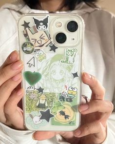 a woman holding up her phone case with stickers on it