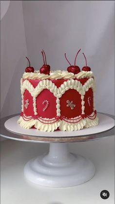 a red and white cake with cherries on top