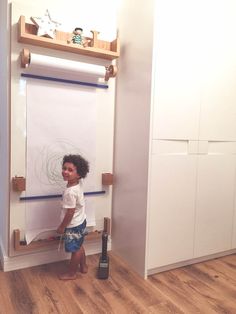 a little boy standing in front of a white board