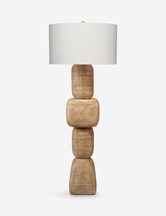 a wooden table lamp with a white shade on it's top and three stacked blocks