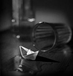 an origami boat sitting on top of a wooden table