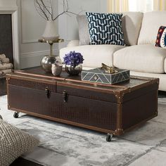 a living room filled with furniture and a large brown trunk on top of a coffee table